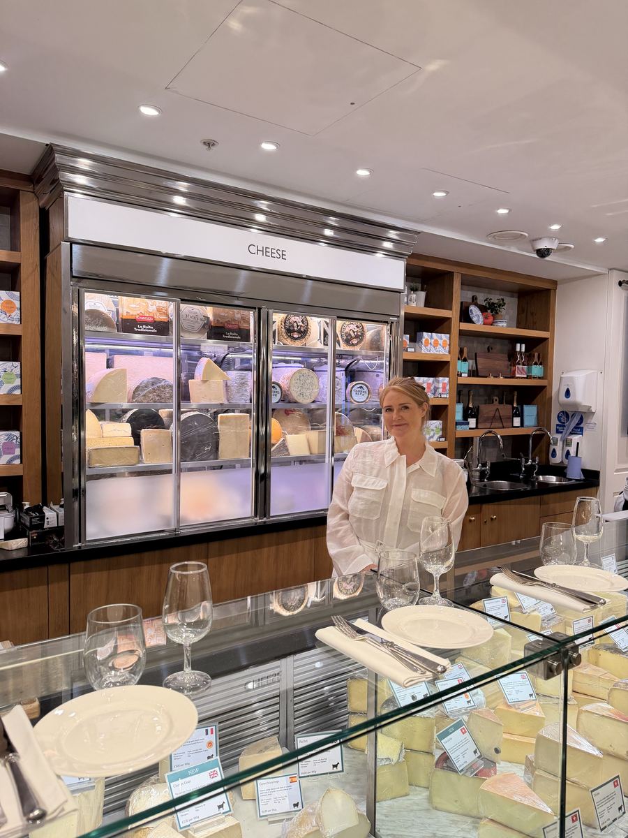 Morgan McGlynn Carr behind the cheese counter in the Fortnum & Mason Food Hall, set with plates and glasses for a Cheese Lates evening
